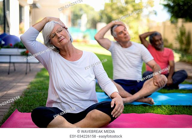 Senior people stretching heads while exercising