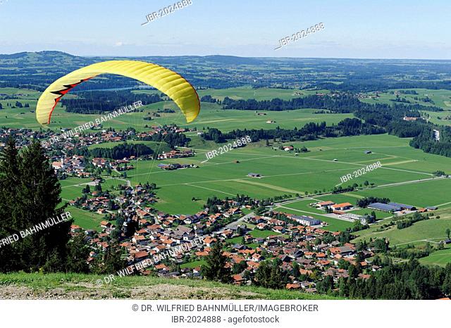 Paraglider gliding from Buchenberg Mountain above Buching, East Allgaeu, Swabia, Bavaria, Germany, Europe