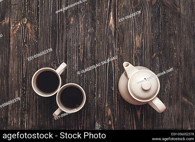 Tea set for the pair. Cups and teapot on black rustic table