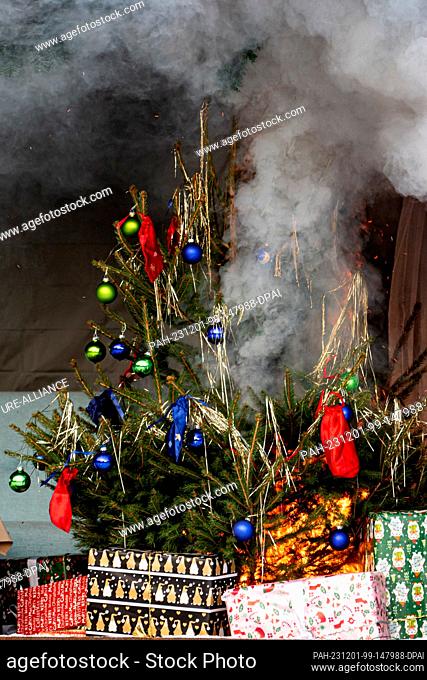 01 December 2023, Berlin: A Christmas tree burns during a demonstration of a fire during the Christmas season on the grounds of the Berlin Fire Academy