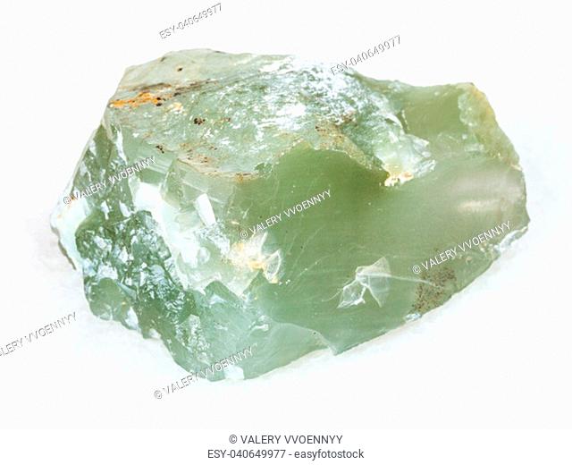 macro shooting of natural mineral - raw Prase (green quartz) stone on white marble from Ural Mountains