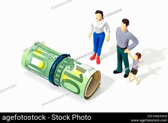 Human representation of a family looking at a Roll of money. Finance, investment or savings concept