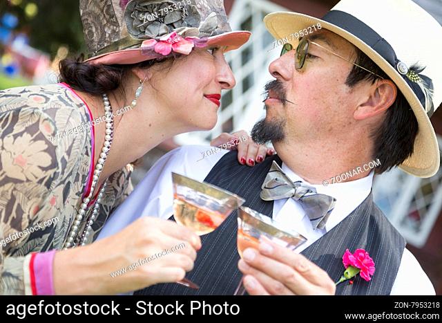 Attractive Mixed-Race Couple Dressed in 1920?s Era Fashion Sipping Champagne