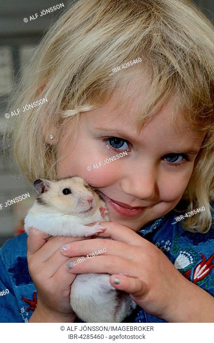 Girl, four years old, with a hamster, Ystad, Scania, Sweden
