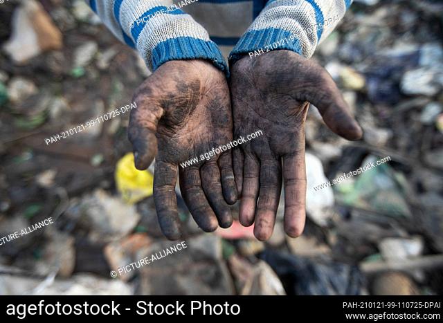 18 January 2021, India, Neu Delhi: Ten-year-old Shekh Zahid shows his hands dirty from collecting garbage at the Bhalswa dumpsite