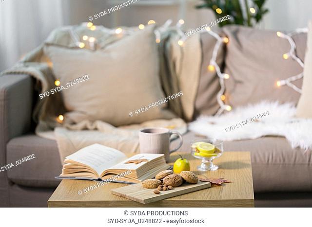 oat cookies, book, tea and lemon on table at home