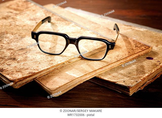 Old writing-books and glasses on a wooden table