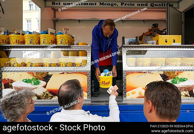 20 August 2021, Saxony, Plauen: The market crier Käse-Maik from Chemnitz sells his cheese on the old market of Plauen. From Friday to Sunday
