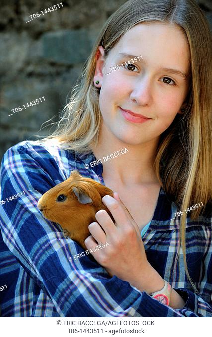 Girl - 13 year old - holding Guinéa pig Cavia porcellus  France