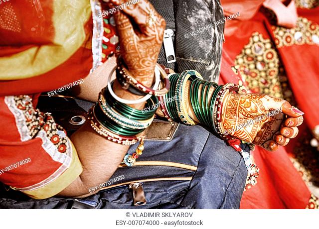 Hands of a young Indian woman adorned with traditional bangles and mehndi. Mehandi, also known as henna is a temporary form of skin decoration in India