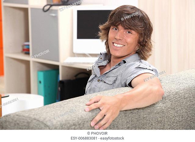 man sitting on a couch and smiling
