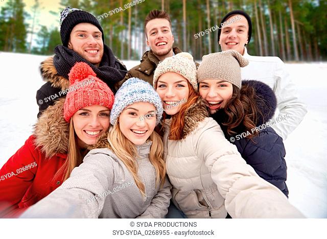 group of friends taking selfie outdoors in winter
