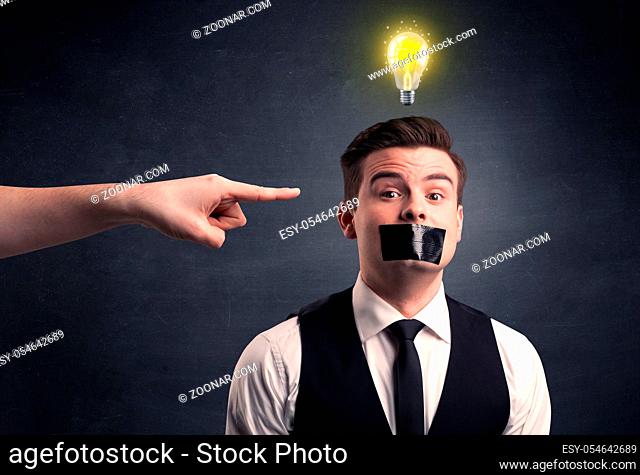 Caucasian hand pointing at businessman with a lightbulb above his head