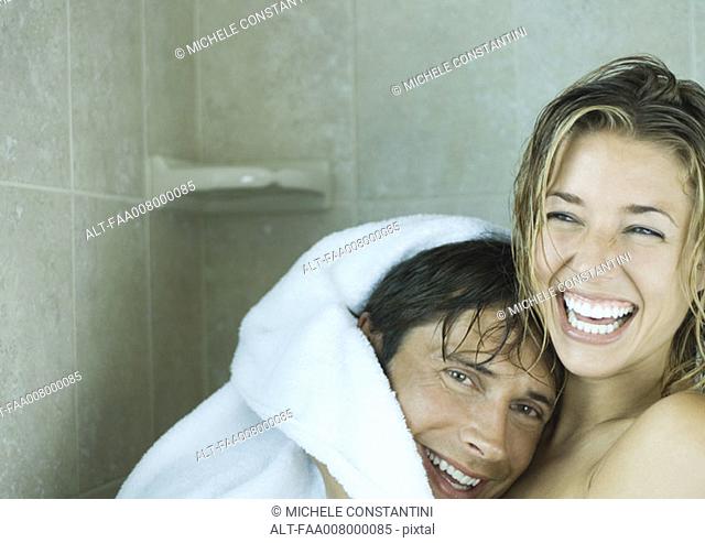 Couple drying off in shower together, laughing