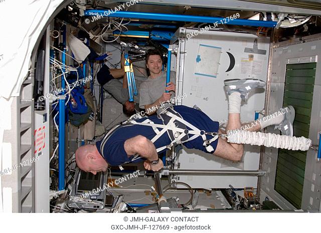 European Space Agency astronaut Andre Kuipers (foreground), Expedition 31 flight engineer, equipped with a bungee harness