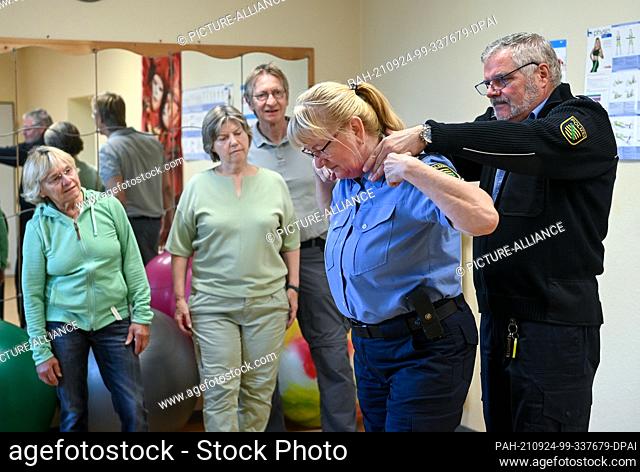 23 September 2021, Saxony, Leipzig: Police officers Stephan Weinhold (r) and Ramona Mertens (2nd from right) demonstrate to participants in an assertiveness...
