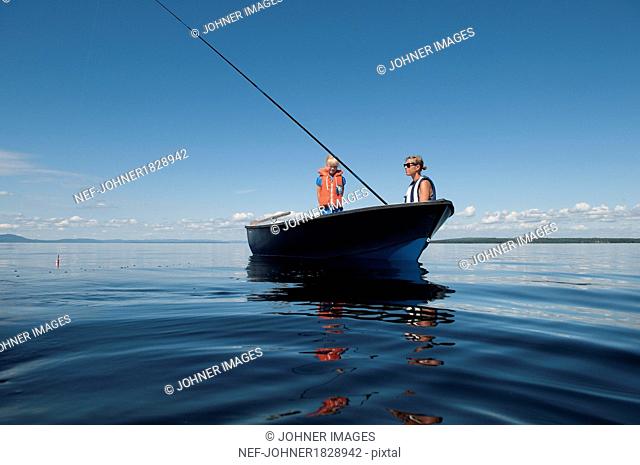 Mother with son fishing on boat