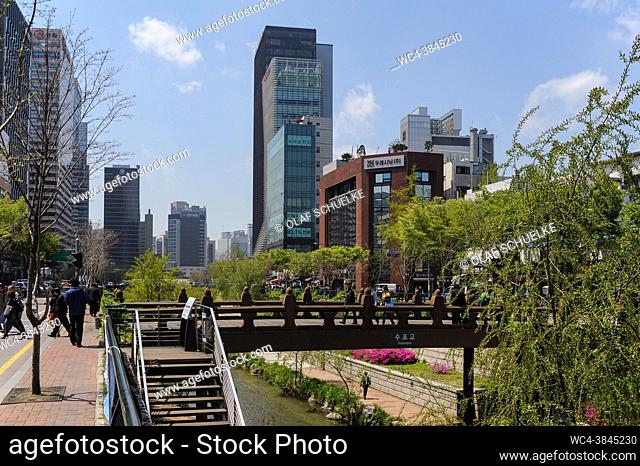 Seoul, South Korea, Asia - Cityscape with people crossing a bridge over the Cheonggyecheon Stream and walkway in the downtown core of the South Korean capital...