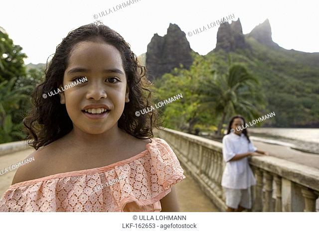 Two girls in front of peaks at Hatiheu, Nuku Hiva, Marquesas, Polynesia, Oceania