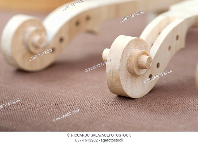 Italy, Lombardy, Cremona, Violin Maker Worshop, Close up of Violin Scrolls Unvarnished