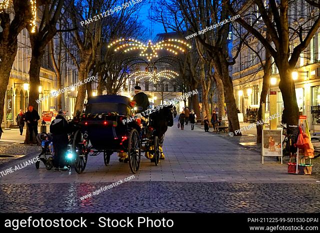 20 December 2021, Thuringia, Weimar: A horse-drawn carriage stands at the beginning of Schillerstrasse in the late afternoon
