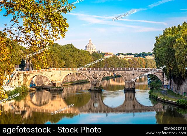 ROME, ITALY - CIRCA AUGUST 2020: Bridge on Tiber river with Vatican Basilica cupola in background and sunrise light