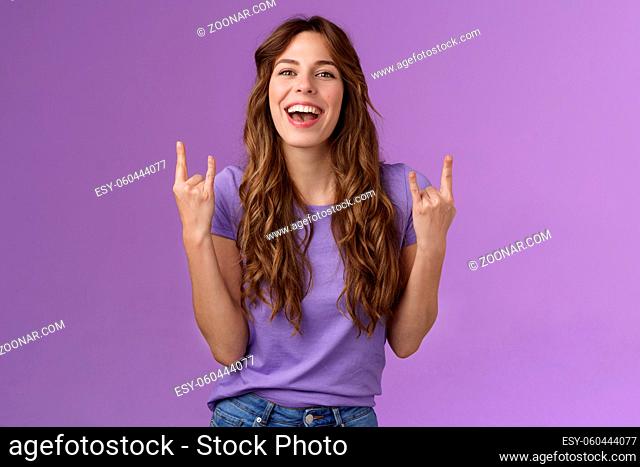 This summer holidays rock. Happy enthusiastic cheerful girl having fun enjoy awesome party weekends smiling broadly say yeah joyful make heavy-metal sign stand...