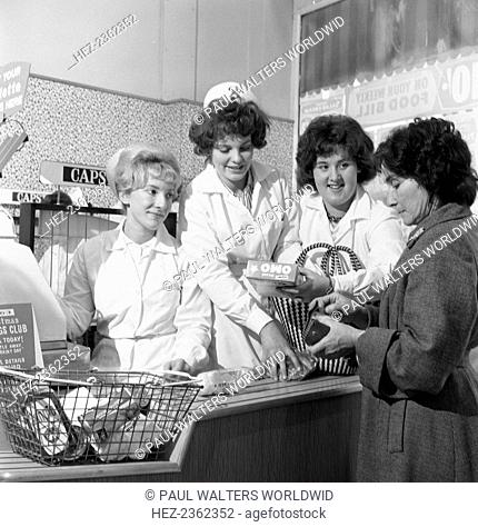 Checkout girls at a supermarket opening, Brough's Ltd, Thurnscoe, South Yorkshire, 1963. Checkout girls with a customer in the newly refurbished Brough's Ltd...