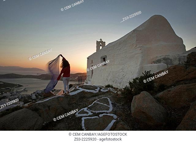Woman in front of a chapel at sunset in Chora, Ios, Cyclades Islands, Greek Islands, Greece, Europe