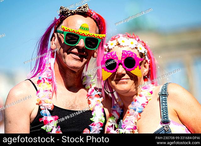 08 July 2023, Berlin: Two people wearing sunglasses stand on the ""Rave the Planet"" techno parade on Straße des 17 Juni