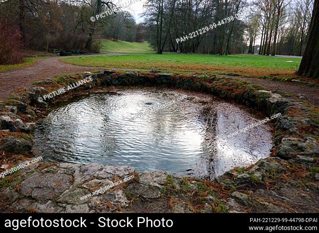 23 December 2022, Thuringia, Weimar: The ox-eye in the park on the Ilm River, created as an artificial stone circle, frames one of the springs of the Läutra...