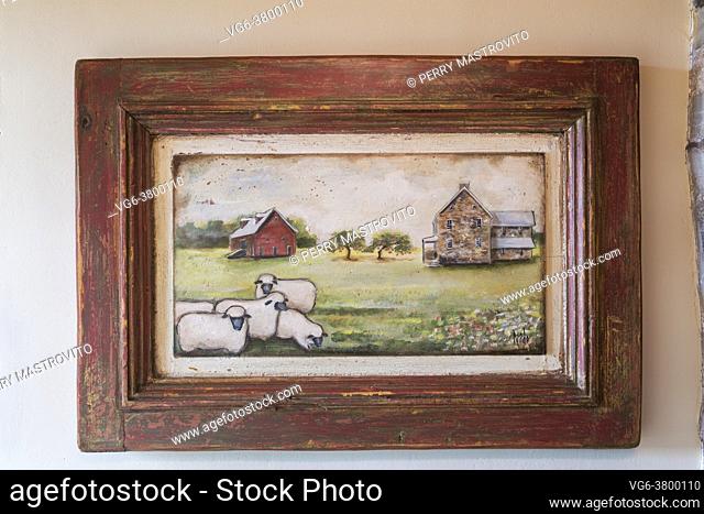 Painting of sheep in pasture and old home and barn in distressed antique wooden frame on wall in entryway inside an old circa 1735 Canadiana fieldstone house