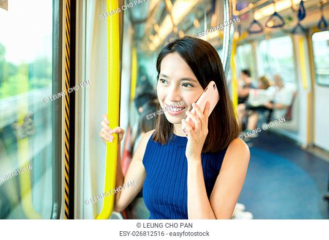 Woman talk to cellphone inside MTR in Hong Kong
