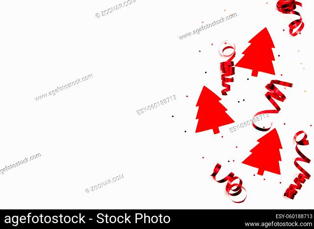 Christmas trees with red ribbons and glitter stars on white background. High quality photo
