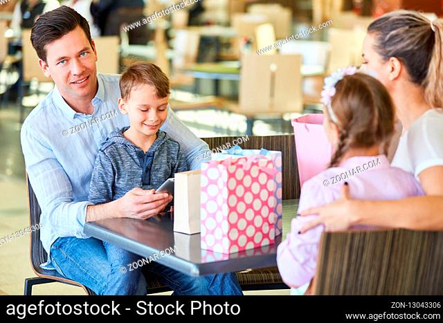 Familie und zwei Kinder macht Pause beim Einkaufen im Shoppingcenter