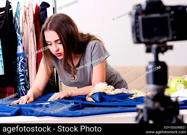 Young beautiful female tailor recording video for her blog