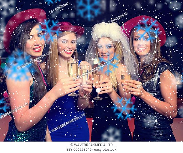 Attractive friends clinking champagne glasses at hen night against snowflakes