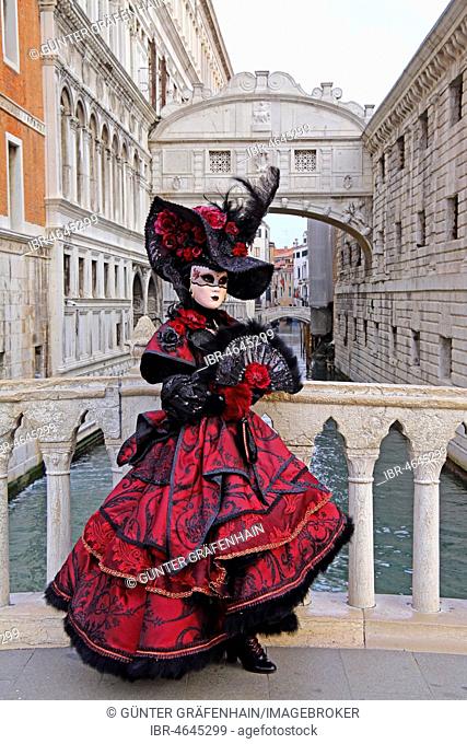 Female disguised with Venetian mask in front of Bridge of Sighs, Carnival in Venice, Italy