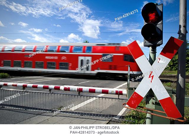 A regional train passes a railroad crossing in Meerbusch, Germany, 17 September 2013. German railway company Deutsche Bahn