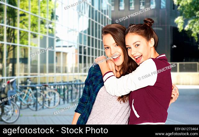 happy smiling teenage girls hugging in city