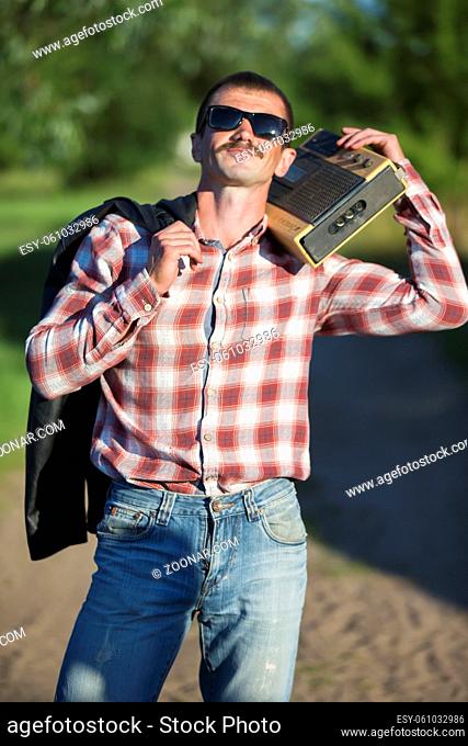 Funny man dressed in the style of the nineties with a cassette recorder