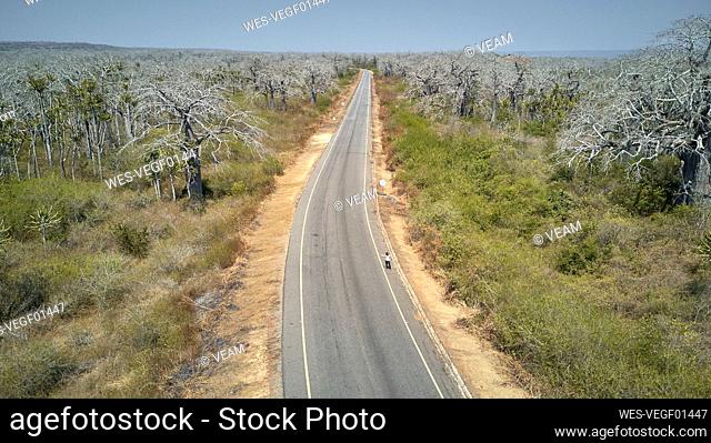 Aerial view of a woman at a road hitchhiking, Cabo Ledo area, Angola
