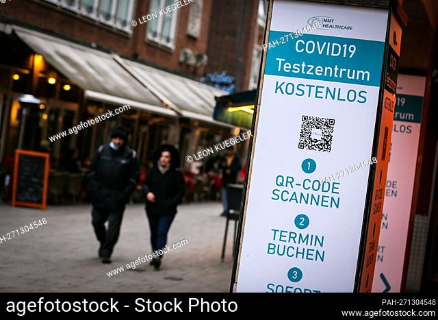 Passers-by pass a COVID-19 test center in the old town of Duesseldorf, January 19, 2022. - Dusseldorf/Deutschland