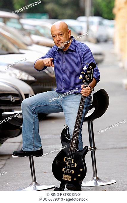 Singer and songwriter Enrico Ruggeri in the street, holding his guitar. 2008