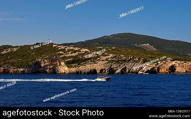 Ionian Islands, Zakynthos, northeast coast, Blue Caves, Blue Grottoes, morning light, excursion boat drives quickly from left to right, behind the grottos
