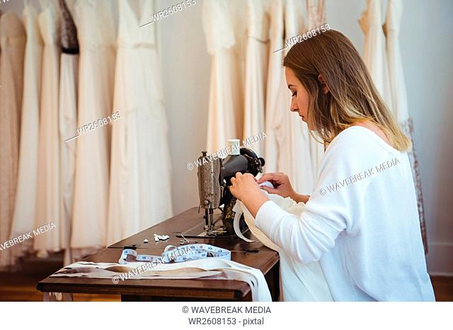 Female dressmaker sewing in the studio