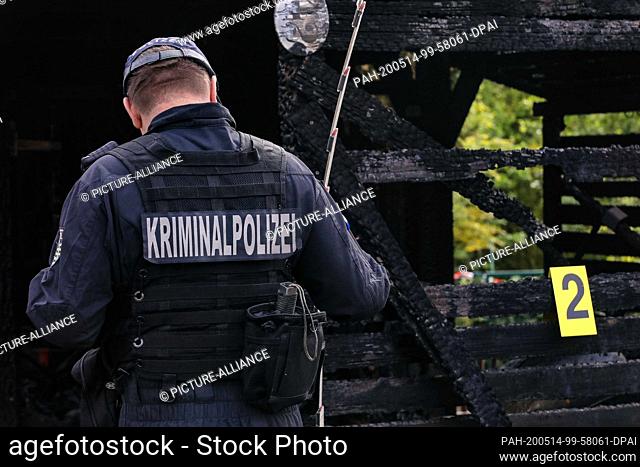 13 May 2020, Saxony, Dresden: Fire investigator with inscription Kriminalpolizei on his back is on the left side of the picture