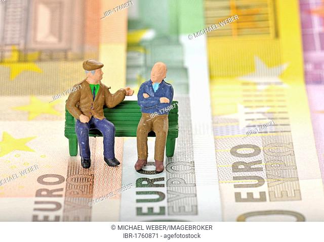 Various euro banknotes with miniature figures of senior citizens on a park bench, symbolic image for pension or retirement