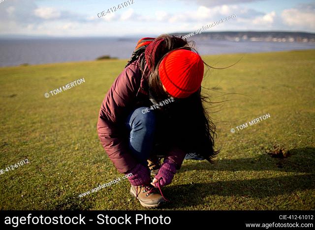 Female hiker tying hiking boot shoelace