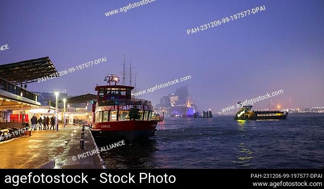 06 December 2023, Hamburg: An HVV harbor ferry docks at the Landungsbrücken in the morning. Photo: Christian Charisius/dpa. - Hamburg/Hamburg/Germany